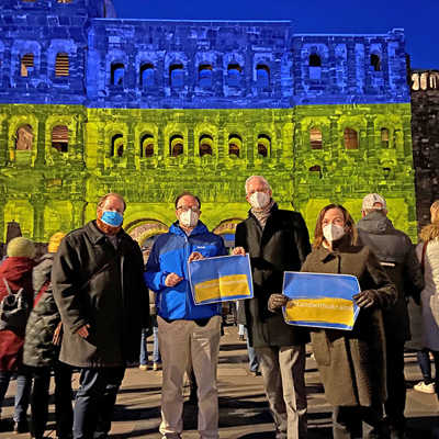 Gemeinsam mit vielen Bürgerinnen und Bürgern drückt der Stadtvorstand vor der Blau-Gelb beleuchteten Porta Nigra seine Solidarität mit der Ukraine aus.