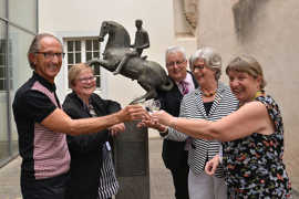 Erwin Löwenbrück, Elke Mohnhaupt-Schmidt, Andreas Ludwig, Elisabeth Ruschel und Christine Meißner stoßen vor dem Rathaussaal am Kunstwerk aus der Trierer Partnerstadt Herzogenbusch auf ihre Freundschaft an.