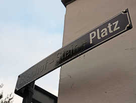 Teilweise übermaltes Straßenschild "Bischof-Stein-Platz"