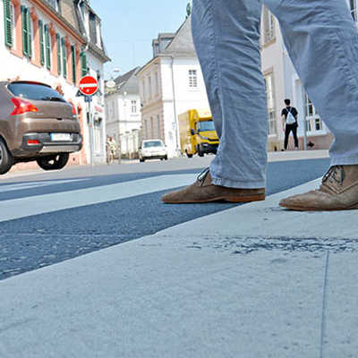 Ein Fußgänger überquert die Straße auf einem Zebrastreifen