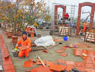 Ein Gartenarbeiter aus Xiamen hält eine der aus China importierten Ziegelplatten, die auf der Plattform des Partnerschaftsgartens verlegt werden. Im Hintergrund wird an einem der Windschirme gearbeitet.