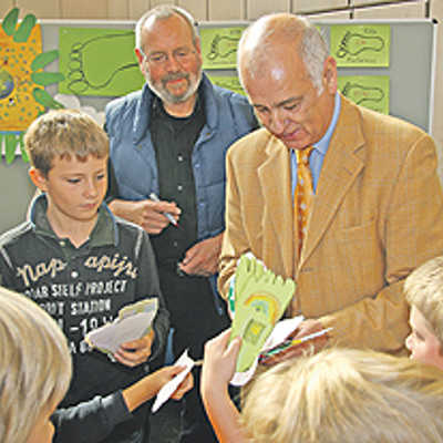Ihre grünen Meilen übergeben die Kinder der Egbert-Grundschule in Form von Fußabdrücken mit Klimatipps. Stadtratsmitglied Bernd Michels verspricht, diese an seine Kollegen weiterzuleiten.