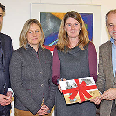 Markus Trost, Geschäftsführer der mediaprint-Gruppe, und zwei der vier Autoren, Susanne Rendenbach und Ingrid Fusenig, überreichen OB Jensen das erste offizielle Buch-Exemplar (von links).