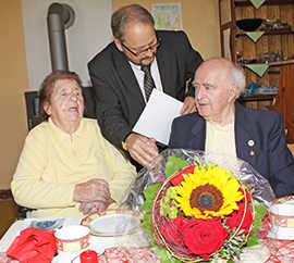 Eurens Ortsvorsteher Hans-Alwin Schmitz gratuliert Maria und Martin Bisenius zur Eisernen Hochzeit. Zuvor hatte er dem Paar einen Blumenstrauß in den Stadtfarben Gelb und Rot überreicht.