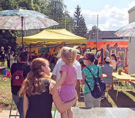 Festliches Treiben auf einer Wiese und Sonnenschirmen und Sonnensegeln