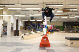 Ein Skater und sein Board befinden sich in der Luft bei einem Trick an einem Rail