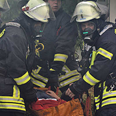 Erfolgreiche Rettung: Vier Feuerwehrmänner konnten einen Verletzten aus Rauch und Flammen retten. Atemschutzmasken bewahrten die Lebensretter davor, selbst ein Opfer zu werden.