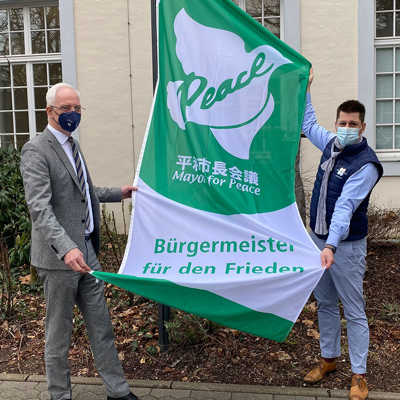 Oberbürgermeister Wolfram Leibe hat aus aktuellem Anlass heute vor dem Trierer Rathaus die Flagge des Friedensbündnisses Mayors for Peace gehisst. Mit dabei: Sein auch für Internationales zuständiger Büroleiter Matthias Berntsen.