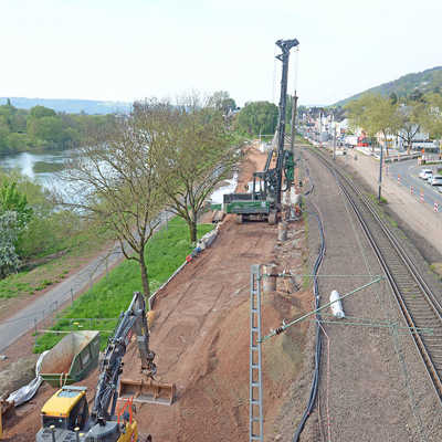 Mit einem Pfahlbohrgerät werden am künftigen Haltepunkt Pallien die Tiefgründungen für einen der 170 Meter langen Bahnsteige verankert. Links verläuft die provisorische Trasse des Moselradwegs.