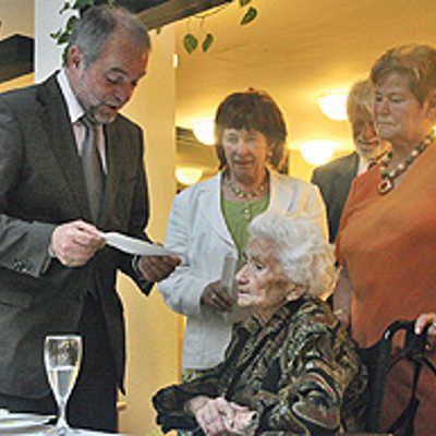 OB Jensen liest Maria Palm im Beisein von Tochter Ellen und Schwiegersohn Helmut Schwartz sowie Tochter Rosi Palm eines der Glückwunschschreiben  zu ihrem 100. Geburtstag vor.
