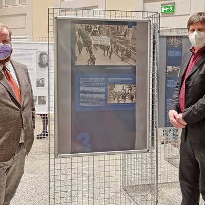Dr. Thomas Grotum (r.) erläutert Dezernent Markus Nöhl einen ergänzenden Teil der Ausstellung, der von der Gedenkstätte Osthofen kommt. Dabei geht es um Übergriffe gegen Juden in der Region. Die Plakate zeigen SA-Truppen, die am 1. April 1933 einen Boykottzug gegen jüdische Läden in Wittlich anführten.