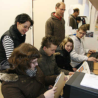 Die Jugendlichen gucken Zeitungen nach Stellenanzeigen durch und arbeiten an den Computern an ihren Bewerbungsunterlagen.