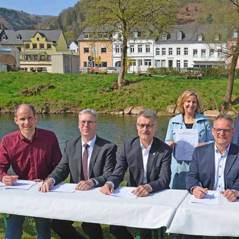 Unterzeichnung der Kooperationsvereinbarung vor Ort an der Kyll mit Dr. Thilo Becker - Beigeordneter der Stadt Trier, Achim Blindert - Allgemeiner Vertreter des Landrates des Kreises Euskirchen, Jan Lembach - Vorsteher des Zweckverbandes Kronenburger See, sowie den Landräten Stefan Metzdorf (Trier-Saarburg), Andreas Kruppert (Bitburg-Prüm) und Julia Gieseking (Vulkaneifel, v. l.). Die Unterzeichnung erfolgte im Beisein der Umwelt- und Klimaschutzministerin von Rheinland-Pfalz, Katrin Eder, sowie von Wolfgang Treis - Präsident der SGD Nord.
