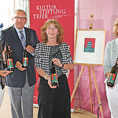 Hiltrud Zock (Agenturhaus), Harry Thiele, Vorsitzender der Kulturstiftung, Ingrid Steiner, Betriebsleiterin der Staatlichen Weinbaudomäne, und ADD-Präsidentin Dagmar Barzen (v. l.) präsentieren die Weinflaschen mit der Künstleredition.