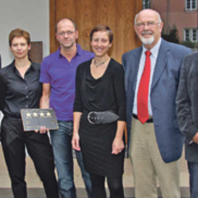 Das Wirtsehepaar Christine und Wolfgang Becker (2. und 3. v. l.) freut sich mit Gratulanten über die Vier-Sterne-Plakette für das Designhotel „Becker’s“.
