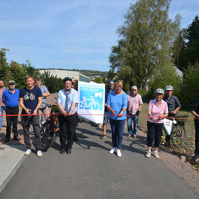 Nach einem Jahr Bauzeit geben Denis Balzer, Eric Wolff (beide Tiefbauamt), Verkehrsdezernent Andreas Ludwig, Ortsvorsteherin Christiane Probst, Monika Thenot (ehemalige Ortsvorsteherin) und der beauftragte Bauunternehmer Christoph Schnorpfeil (v. l.) den Weg auf dem neuen Abschnitt im Trierer Radverkehrsnetz frei.