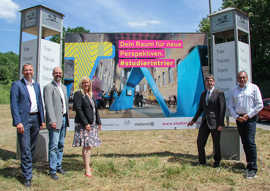 Norbert Käthler, Marc Regier, Christiane Luxem, Michael Jäckel und Thomas Vatheuer (Leiter der Unternehmenskommunikation Studiwerk, v. l.) präsentieren eine große Plakatwand an der Olewiger Straße.