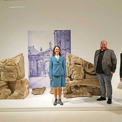 In der neuen Ausstellung zu sehen sind unter anderem erhaltene Bauteile (Wappenlöwen) des 1875 abgebrochenen Simeonstores neben der Porta Nigra. Museumsdirektorin Dr. Viola Skiba, Kulturdezernent Markus Nöhl und Kurator Dr. Bernd Röder (v. l.) freuen sich auf viele Gäste. Foto: Bernhard Matthias Lutz, Stadtmuseum
