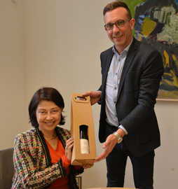Sudawan Vadhayakorn, die Enkelin des Komponisten der thailändischen Nationalhymne, erhält von Dezernent Thomas Schmitt eine Flasche OB-Wein.