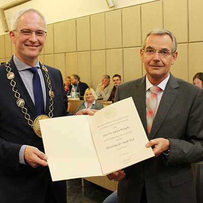 Oberbürgermeister Wolfram Leibe (l.) bedankt sich im Rathaussaal mit einer Urkunde für das Engagement von Dr. Ulrich Dempfle.