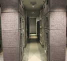 Die Kammer in St. Michael ist schlicht gestaltet. Große Bodenplatten führen zwischen den hell angeleuchteten Urnengräbern lang. Am Eingang fällt das eingravierte „Vaterunser“ in Latein und Deutsch auf. Foto: Annders