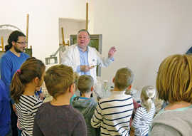 Restaurator Dimitri Scher zeigt den Kindern, mit welchen Werkzeugen und Mitteln er alte Bilder wieder zum Glänzen bringt.