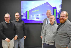 Fünf Personen stehen vor einem Bildschirm, auf dem ein Bild der künftigen SWT-Arena zu sehen ist.