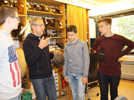 Chefmaskenbildner Rüdiger Erbel erläutert drei Jugendlichen, wie in den Theaterwerkstätten Perücken hergestellt werden.