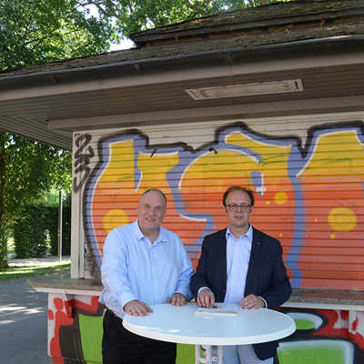 Nach der Vertragsunterzeichnung vor dem Kiosk im Palastgarten freuen sich Innenstadtdezernent Ralf Britten (r.) und Pächter Niels Becker auf die Zusammenarbeit.
