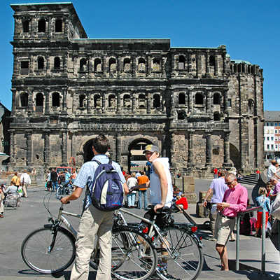 Für Tagestouristen, egal ob sie mit dem Rad, zu Fuß oder mit dem Bus in Trier unterwegs sind, darf ein Besuch an der Porta Nigra nicht fehlen. Dort starten auch zahlreiche Führungen. 