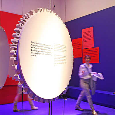Zahnräder sind ein wiederkehrendes Stilelement der Ausstellung im Landesmuseum. Dieser Raum befasst sich mit dem Kommunistischen Manifest.