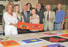 Stolz präsentieren die zwölfjährige Janine (Mitte) und Jugendclub-Leiterin Marita Wollscheid (l.) bei der Spendenübergabe zwei Werke der Kunstaktion