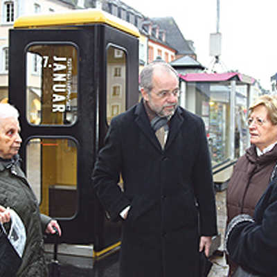 OB Klaus Jensen im Gespräch mit vier Triererinnen, die ihre Erinnerungen zu der Zeitzeugenaktion beigetragen haben. Im Hintergrund die Telefonzelle, in der die Mitschnitte angehört werden können.