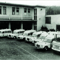 Schwarz-weiß Foto: Die acht Rettungsfahrzeuge der Feuerwehr stehen aufgereiht im Hof der Feuerwache 1.