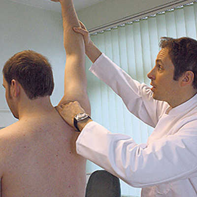 Der Trierer Orthopäde Dr. Christian Fink untersucht das Schultergelenk eines Patienten.