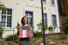 Bürgermeisterin Elvira Garbes präsentiert den Info-Flyer für die Solidarkarte vor dem Trierer Rathaus.