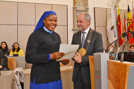 Die aus Nigeria stammende Schwester Olivia Chebechukvou Ekweariri erhält von OB Klaus Jensen die Urkunde, die sie zur deutschen Staatsbürgerin macht. 