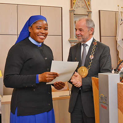 Die aus Nigeria stammende Schwester Olivia Chebechukvou Ekweariri erhält von OB Klaus Jensen die Urkunde, die sie zur deutschen Staatsbürgerin macht. 