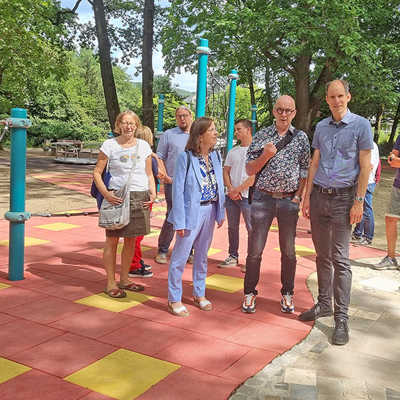 Der erneuerte Spielplatz im Park Nells Ländchen steht seit Mai wieder zur Verfügung und wurde am Donnerstag mit einem Ortstermin offiziell eingeweiht. Dabei nahmen unter anderen Bürgermeisterin Elvira Garbes, Behindertenbeauftragter Gerd Dahm und Baudezernent Thilo Becker (vorn, v. l.) den in gelben und roten Kacheln angelegten Fallschutzboden und das angrenzende Mosaik in Augenschein.