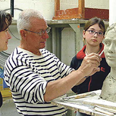 Akademie-Dozent Peter Rübsam demonstriert zwei Kursteilnehmerinnen den „Feinschliff“für die Gestaltung eines Porträtkopfes aus Ton. Foto: Europäische Kunstakademie