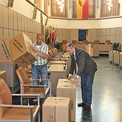 Stellprobe im Rathaussaal: Bevor zusätzliche Ratspulte bestellt werden, machen sich OB Klaus Jensen und Hausmeister Uwe Mischtian mit Hilfe von Umzugskartons schon mal ein Bild von der geplanten neuen Sitzordnung.