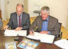 OB Klaus Jensen und der Vorsitzende der Trier-Gesellschaft, Karlheinz Scheurer (r.), unterzeichnen den Vertrag. Foto: PA