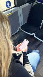 Ein Fahrgast in einem Bus ruft Daten von einem Smartphone ab.