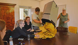 Vier Helfer im Briefwahlbezirk 6002 entleeren um 18 Uhr im Trier-Zimmer eine Urne mit den Stimmzettelumschlägen.