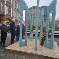 Beigeordneter Dr. Thilo Becker, Landrat Stefan Metzdorf, OB Wolfram Leibe, Detlef Placzek, Opferbeauftragter der Landesregierung, und Kulturdezernent Markus Nöhl stehen in stillem Gedenken vor den Stelen des Denkmals