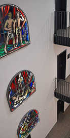 Im Treppenhaus erinnert Glaskunst an die frühere Kirche.