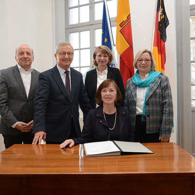 Rudolf Fries (Leiter des Bildungs- und Medienzentrums), Dr. Manfred Bitter und Sabine Plate-Betz (Vorstand Nikolaus Koch Stiftung), Bürgermeisterin Elvira Garbes (vorne) und Gisela von Auer (Stiftung Polytechnische Gesellschaft Frankfurt am Main) bei der Vertragsunterzeichnung (v.l.). Foto: Presseamt Stadt Trier