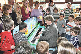 Musiklehrer Martin Folz weiht mit Schülern der Grundschule das „Kinderklavier“ ein.