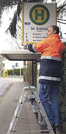 Guido Schäfer, Mitarbeiter der Verkehrsbetriebe, rüstet eine Haltestelle auf der Weismark mit einen neuen Schild aus. Foto: SWT