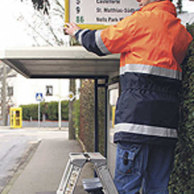 Guido Schäfer, Mitarbeiter der Verkehrsbetriebe, rüstet eine Haltestelle auf der Weismark mit einen neuen Schild aus. Foto: SWT